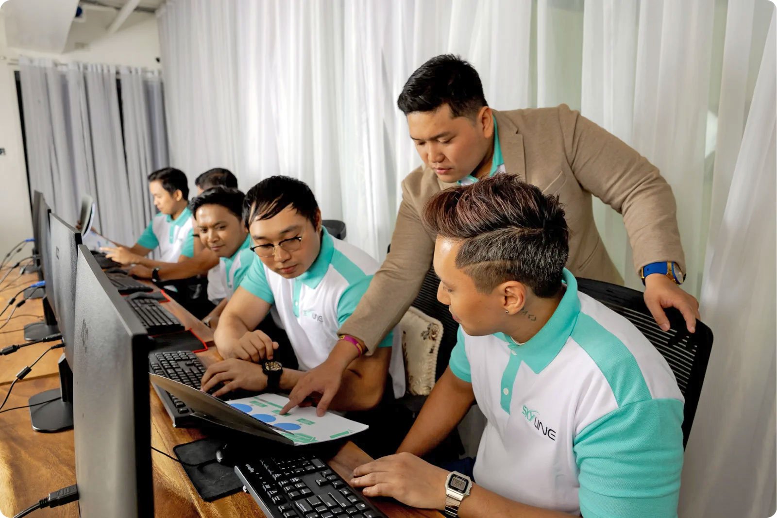 Skyline team members actively engaging at their workstations, strategizing on cryptocurrency projects, in an office setting.